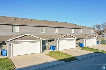 A home with two garages and a street in front of it